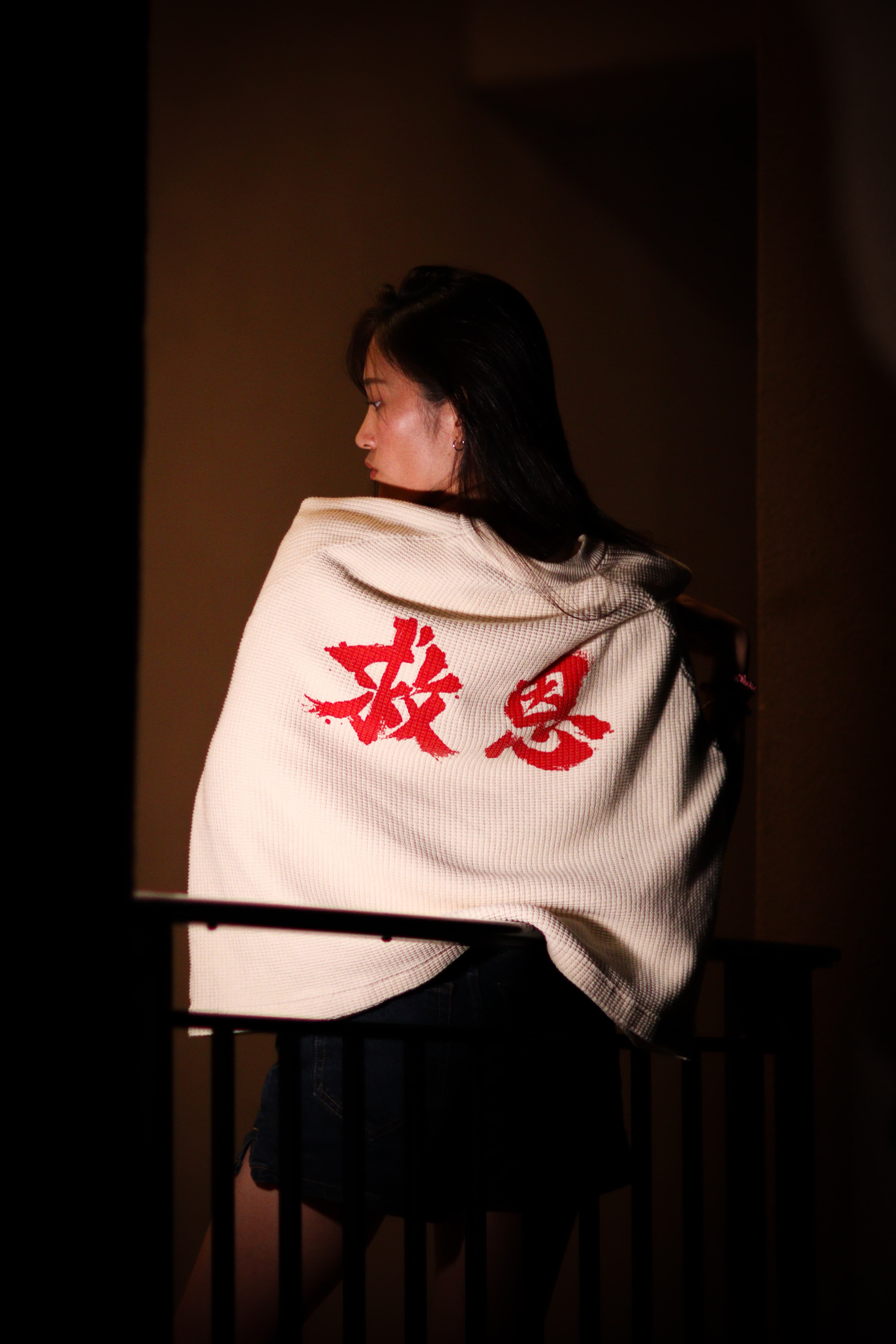 On-model, back, three-quarter angle, worn over the shoulder outdoors at dusk.
