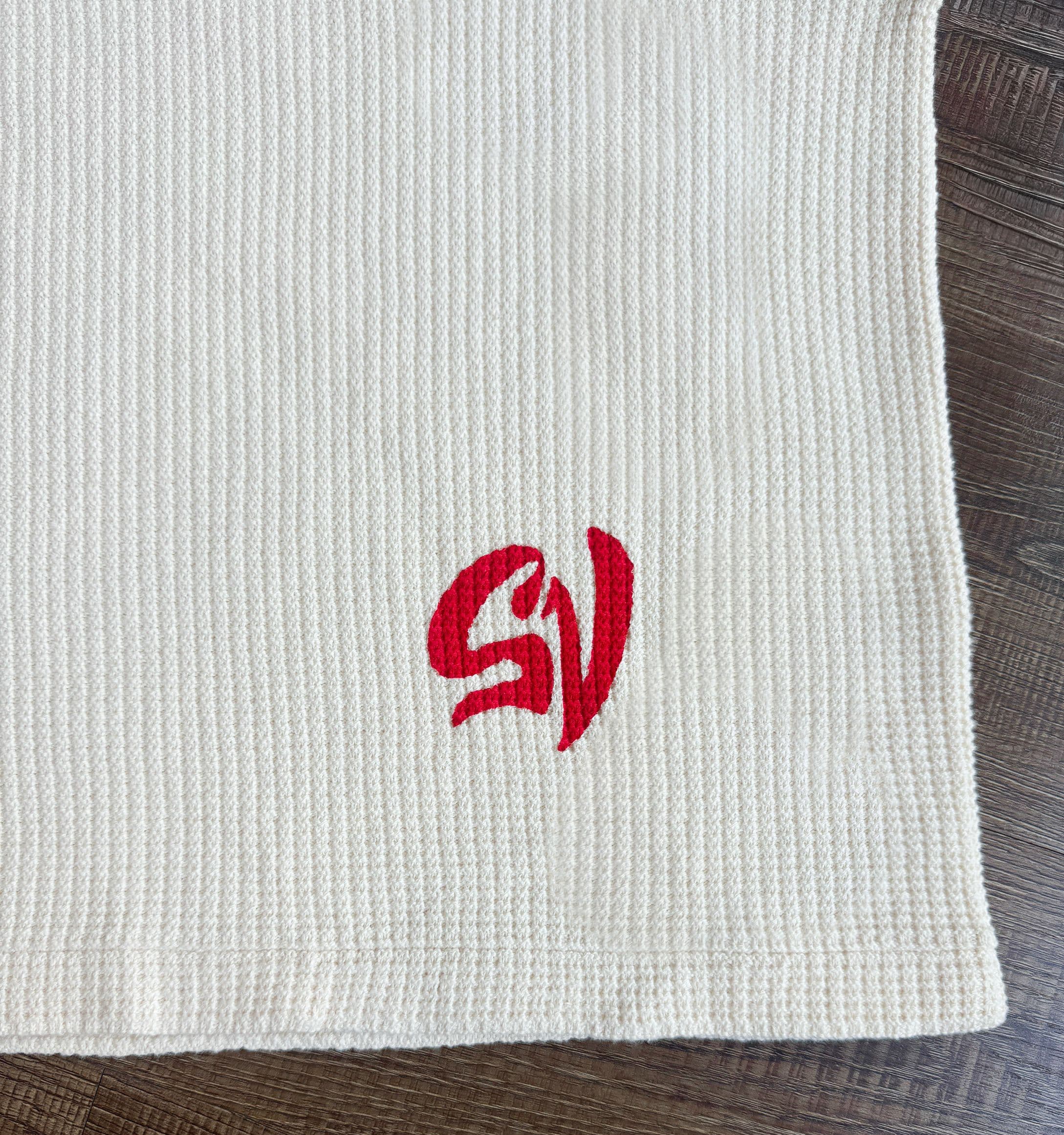 Close-up detail of the waffle knit and the embroidered SV mark.
